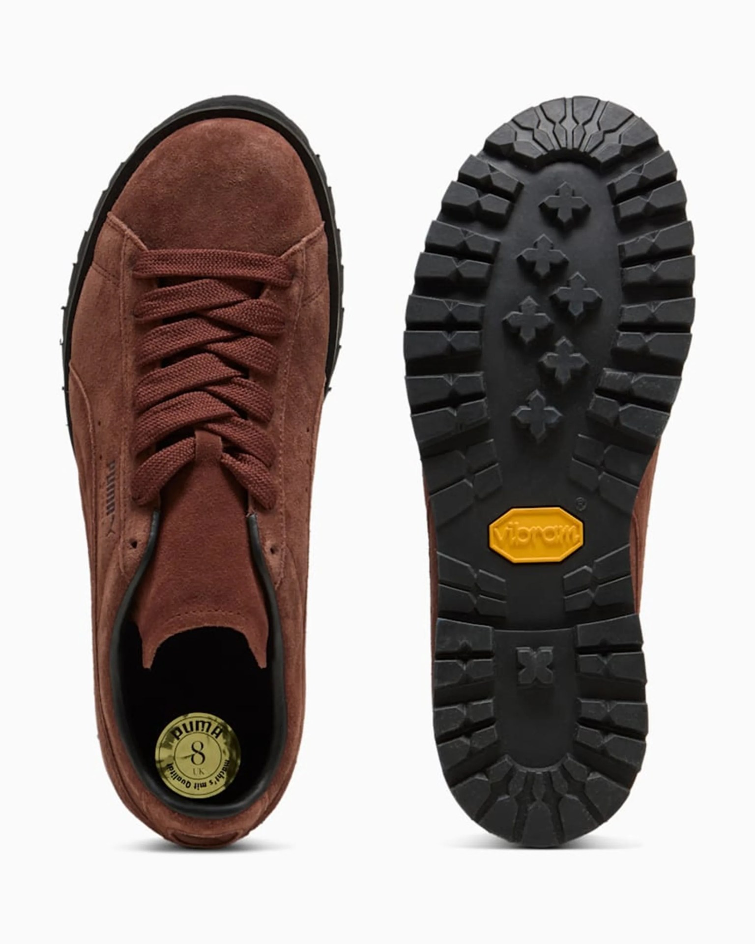 Brown suede Puma shoe with thick black Vibram sole showing tread pattern and size label inside.