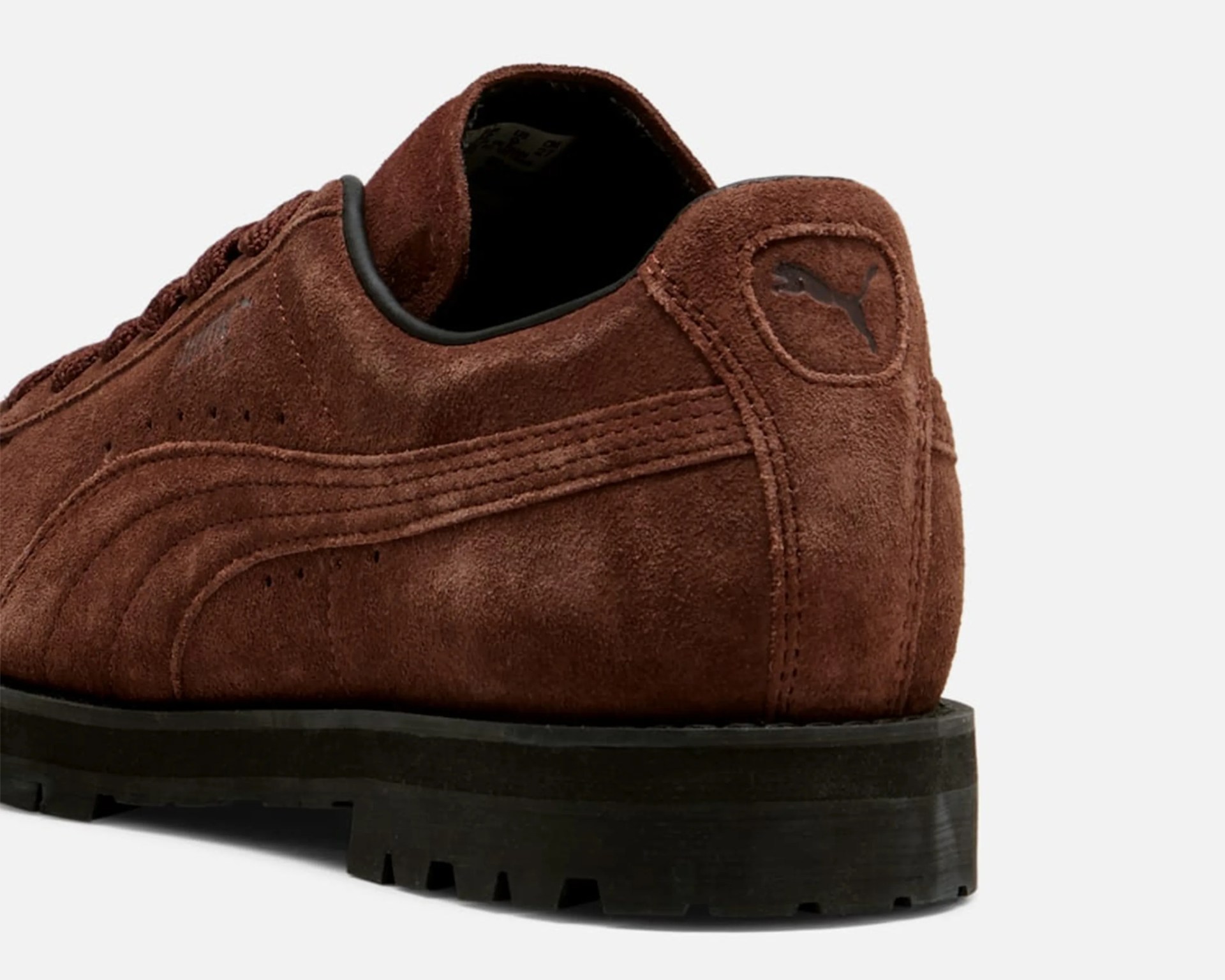 Brown suede Puma shoe heel with black rubber sole and Puma logo on the back.