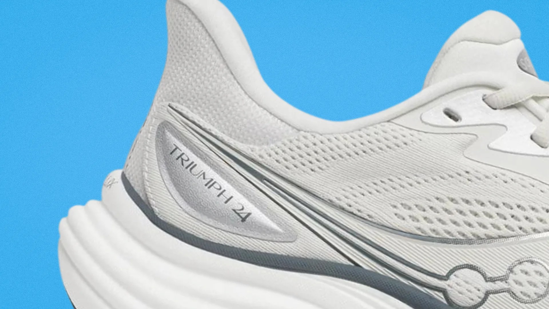 Close-up of a white Saucony Triumph 24 running shoe heel with mesh upper and cushioned sole against a blue background.