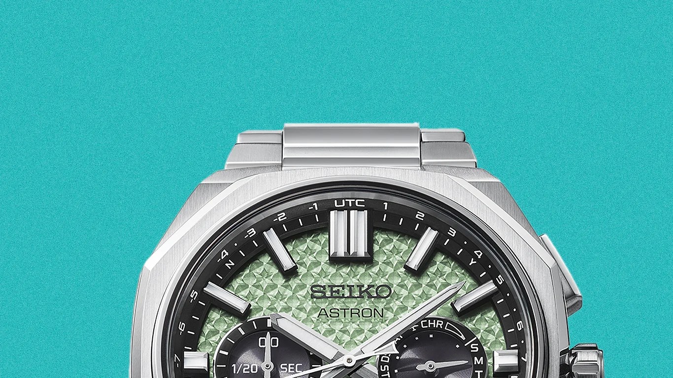 Seiko Astron watch with textured green dial, silver hour markers, and stainless steel case and bracelet.
