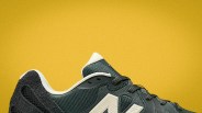 Close-up of a black and white New Balance sneaker against a yellow background.
