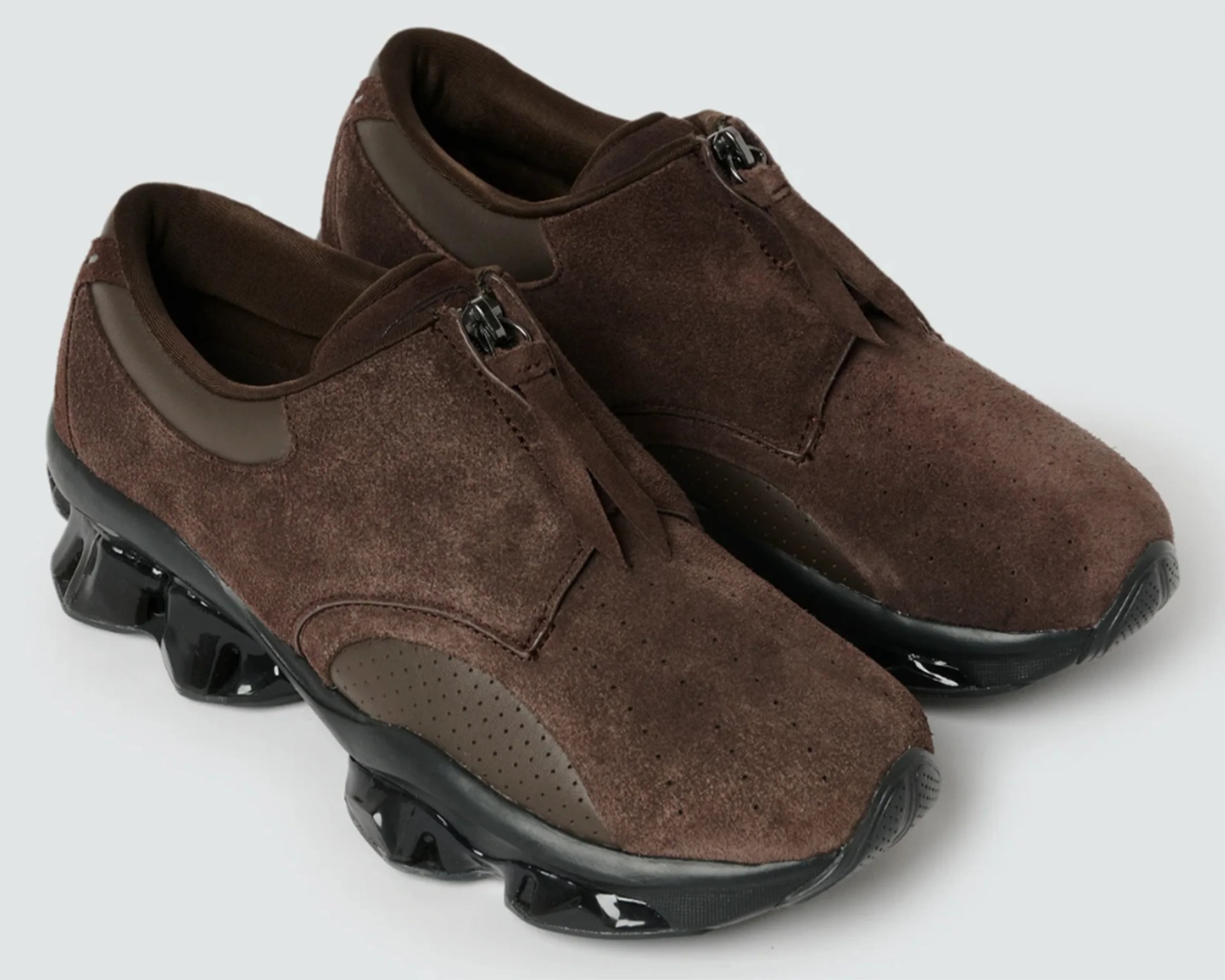 Pair of brown suede sneakers with black chunky soles and zipper closures.