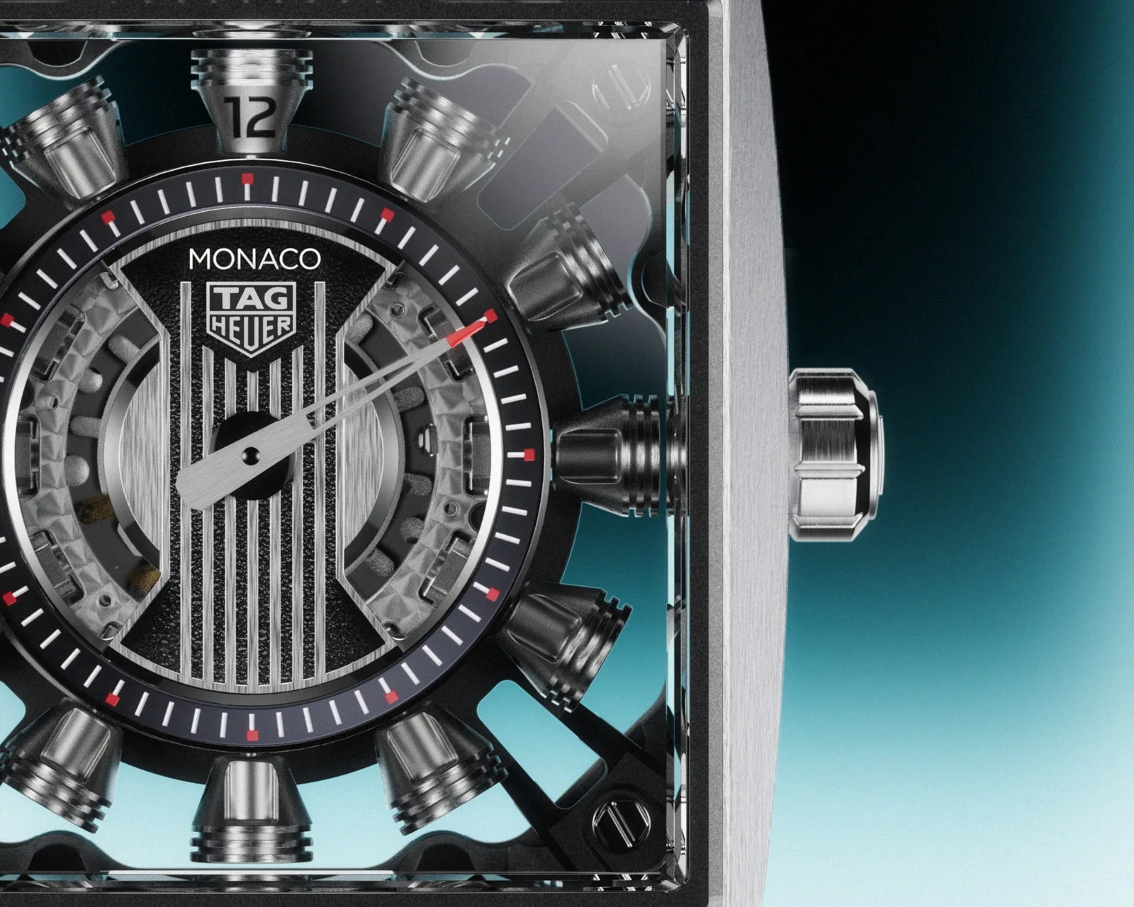 Close-up of a TAG Heuer Monaco watch face with visible mechanical components and a brushed metal crown on the right.