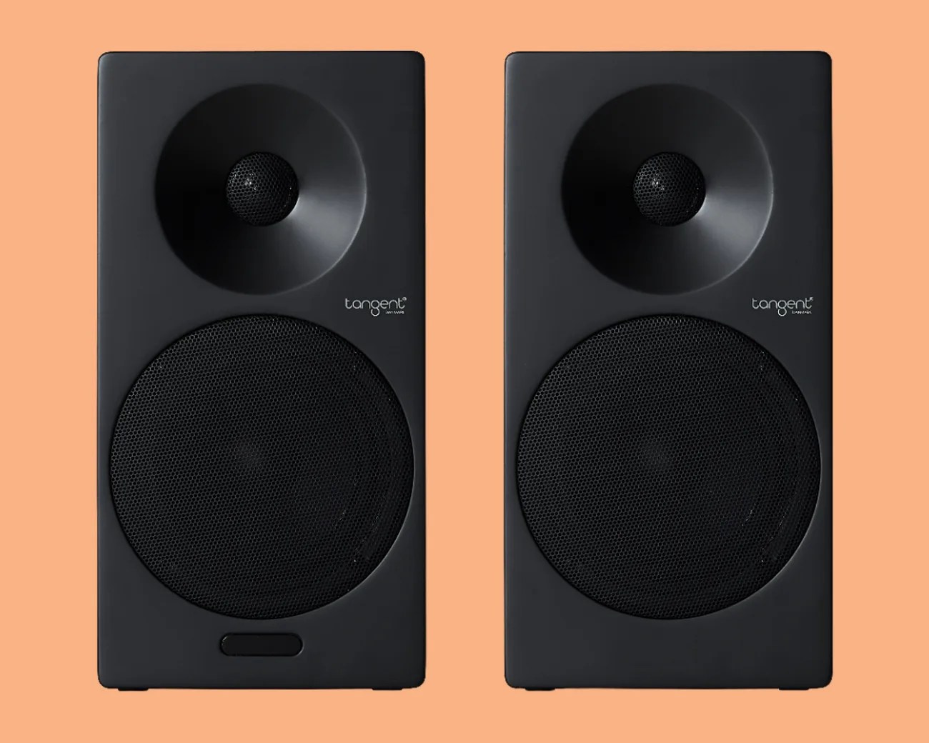 Pair of black Tangent brand bookshelf speakers with mesh-covered woofers and tweeters on a peach background.