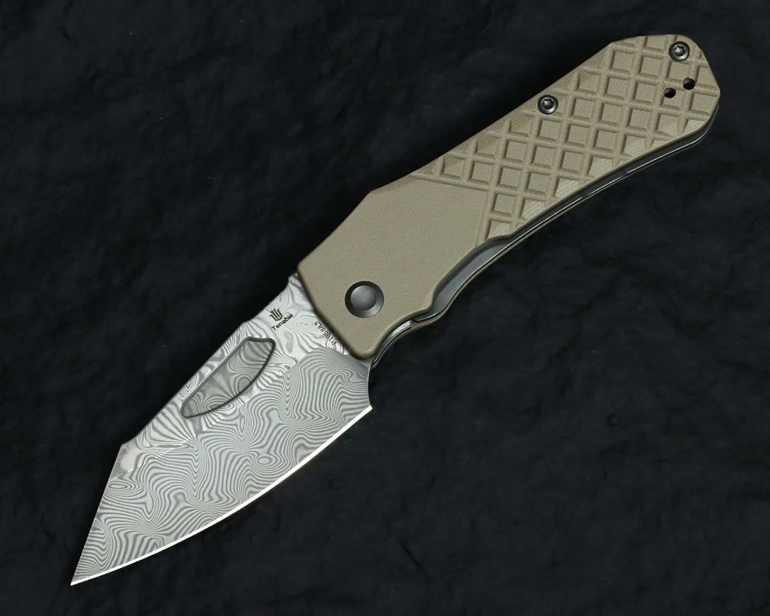 Folding knife with a patterned Damascus steel blade and a textured tan handle on a black surface.