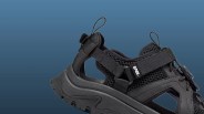 Black Teva sandal with mesh upper, adjustable straps, and rugged sole on a blue background.