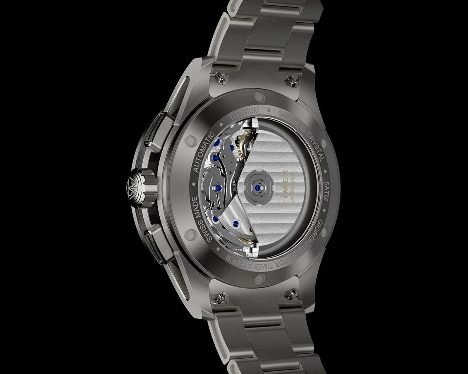 Titanium automatic wristwatch back with visible movement, sapphire crystal, and metal bracelet on black background.