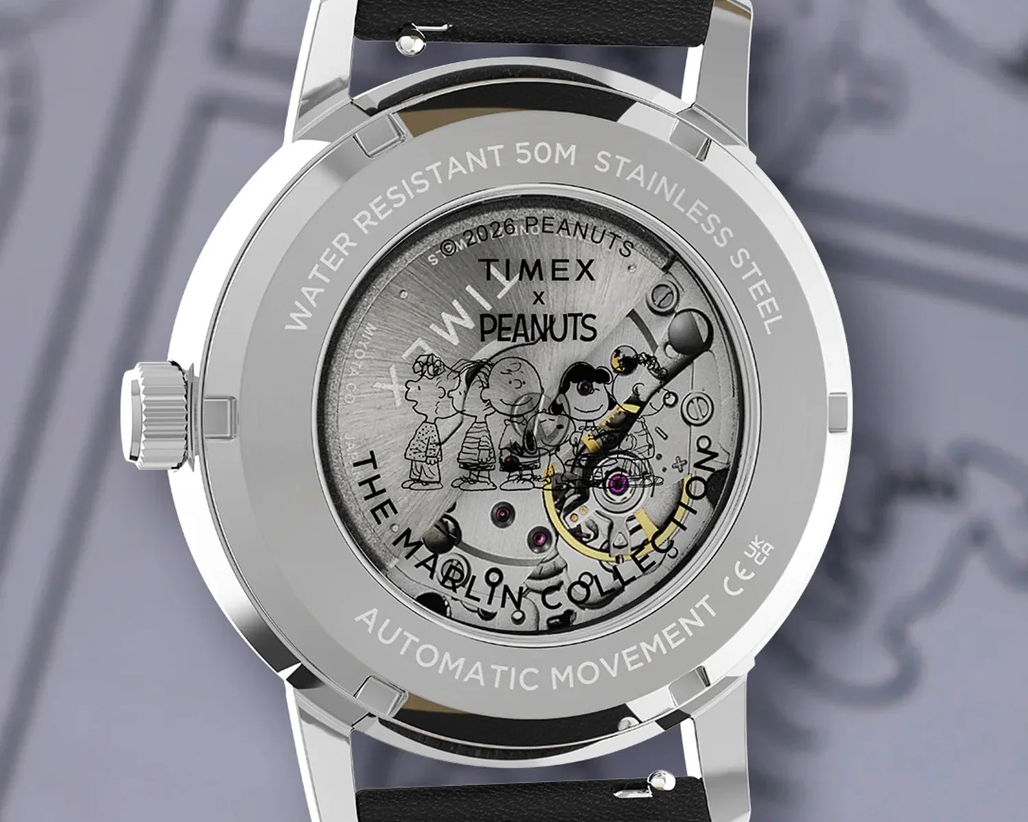 Back of a stainless steel Timex watch with visible automatic movement and Peanuts characters etched inside the case.