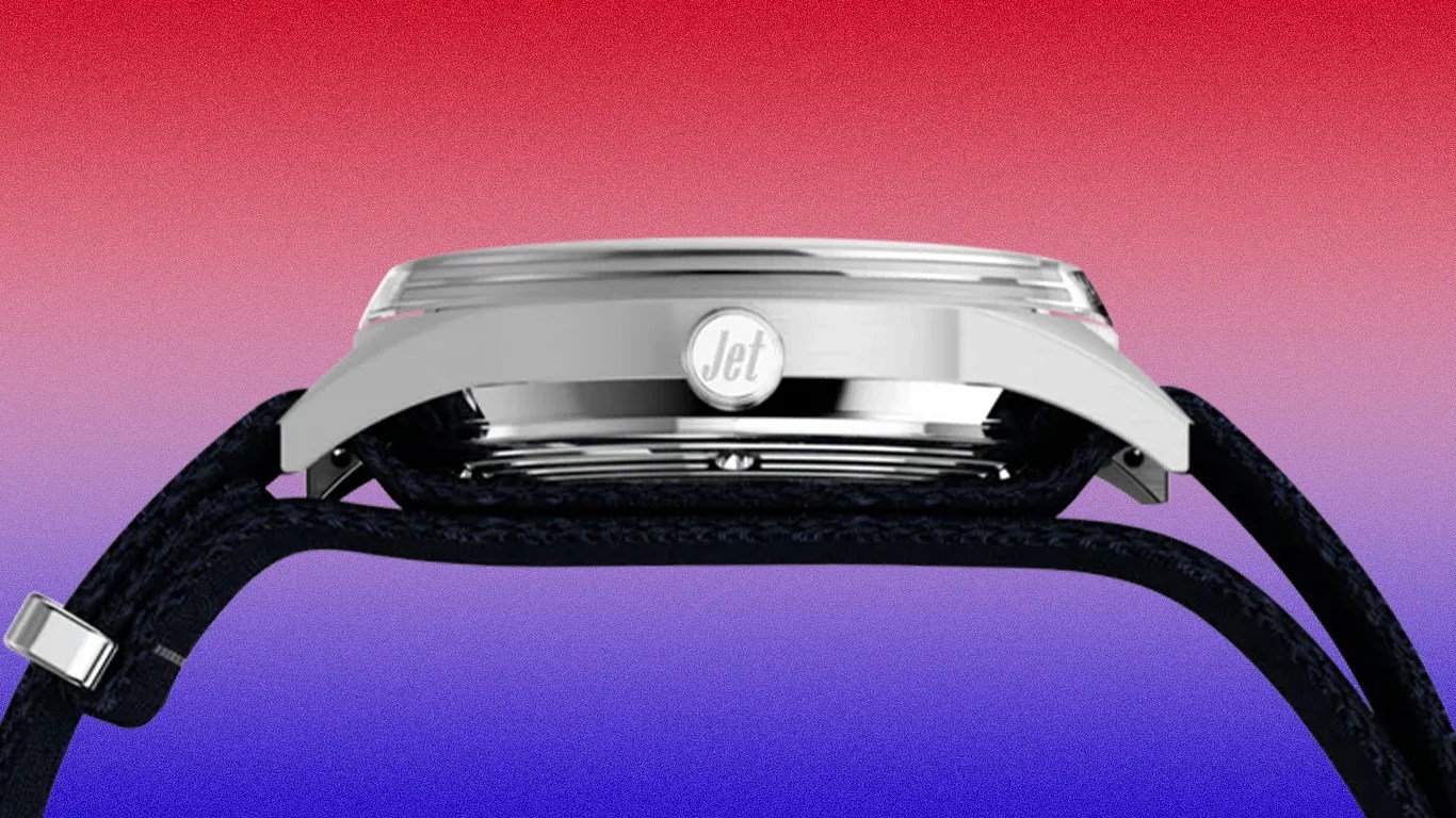 Side view of a silver watch case with "Jet" engraved on the crown and a black textured strap against a red to blue gradient background.