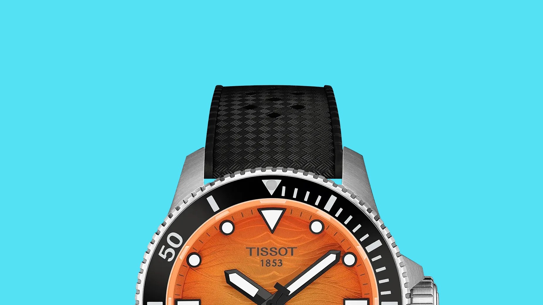 Close-up of a Tissot wristwatch with an orange dial, black bezel, and textured black rubber strap.