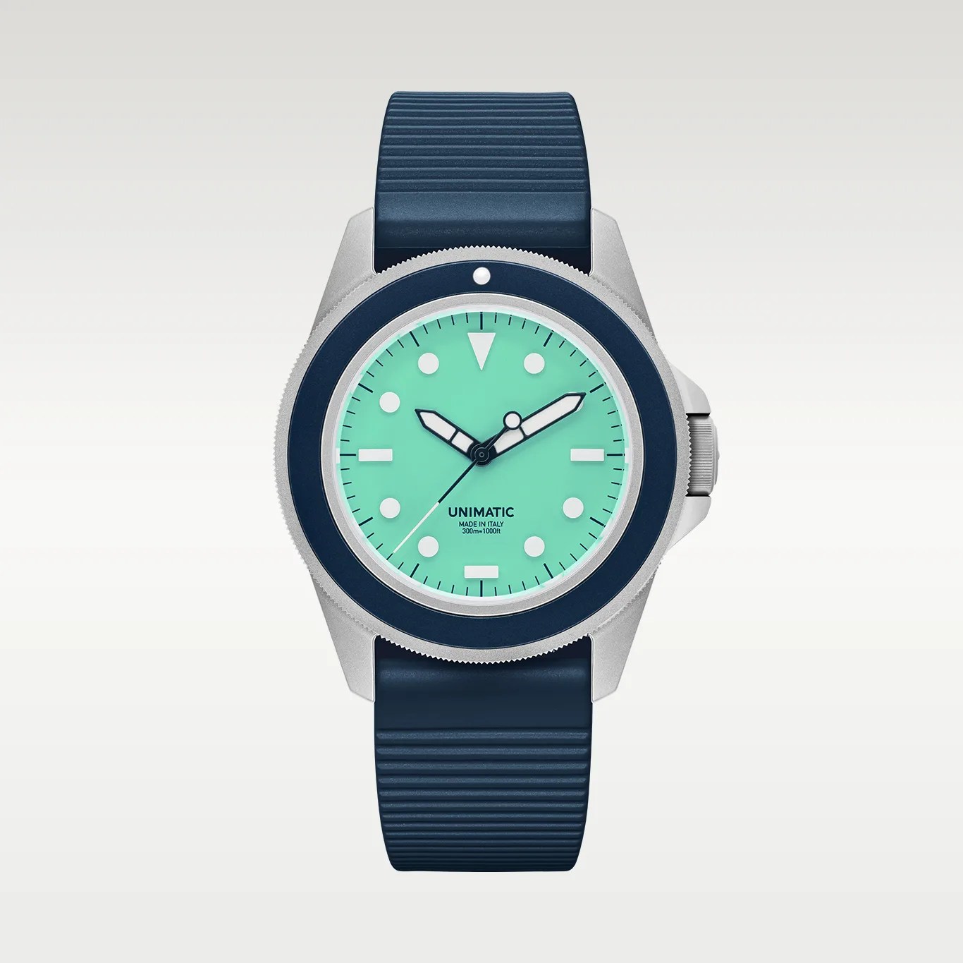 Silver watch with a turquoise dial, navy blue bezel and strap, and white hour markers and hands.