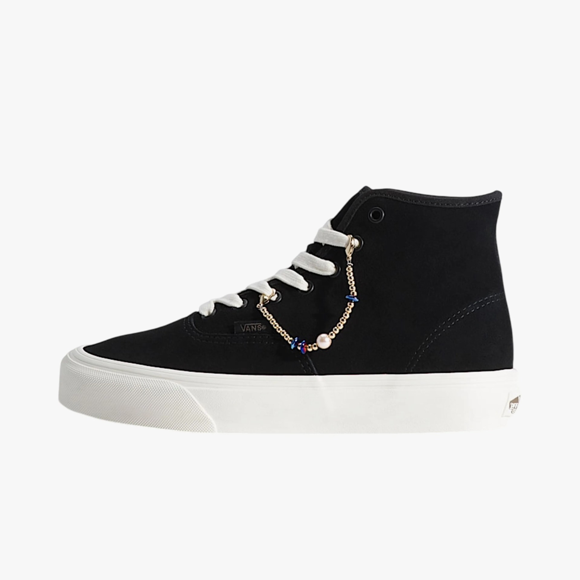 Black Vans high-top sneaker with white laces, white platform sole, and a gold chain accessory with beads.