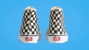 Pair of black-and-white checkered Vans high-top sneakers shown from the back on a blue background.