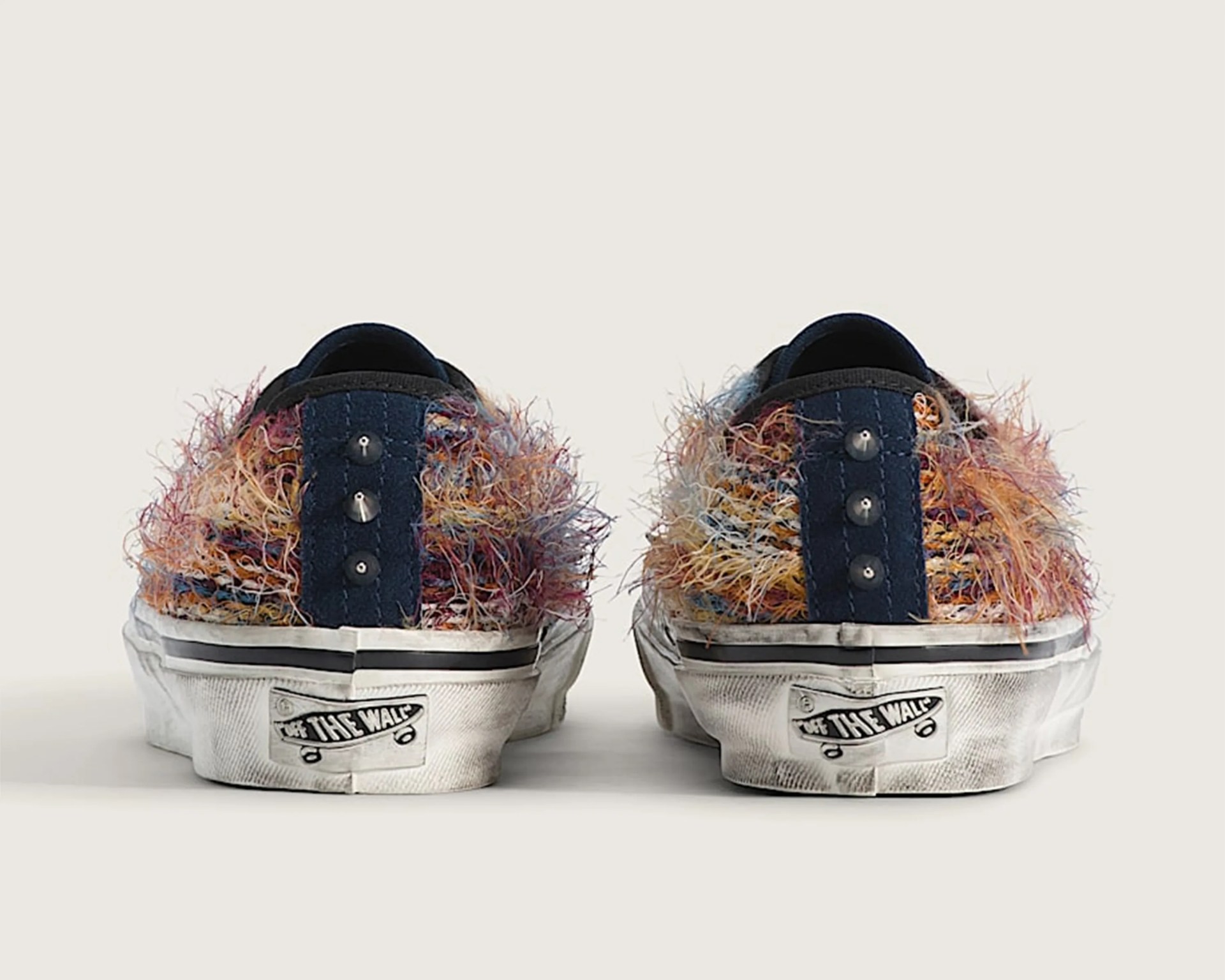 Pair of multicolored fuzzy Vans sneakers shown from the back with white soles and "Off The Wall" logo.