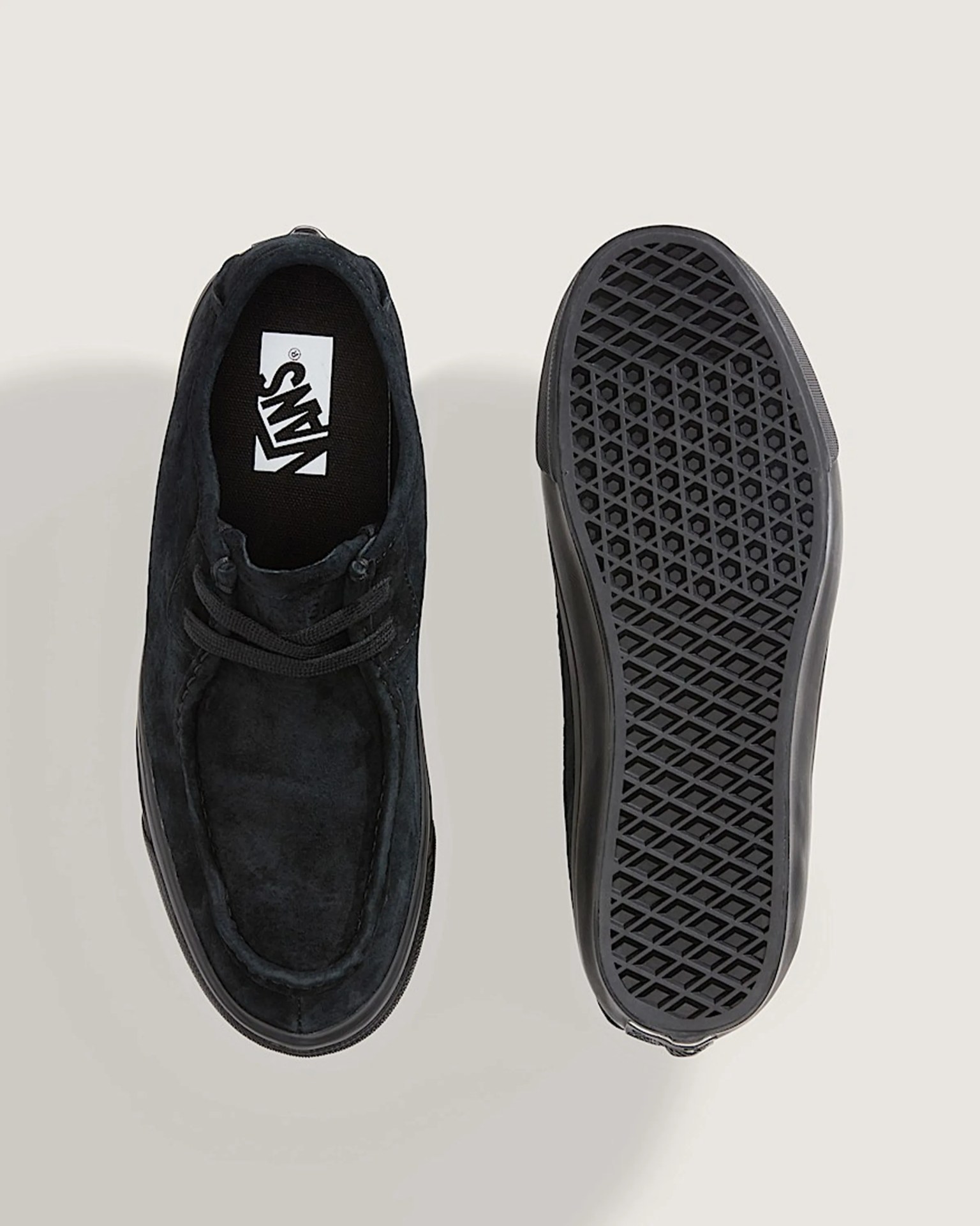 Pair of black suede Vans shoes showing top view of one shoe and sole of the other.