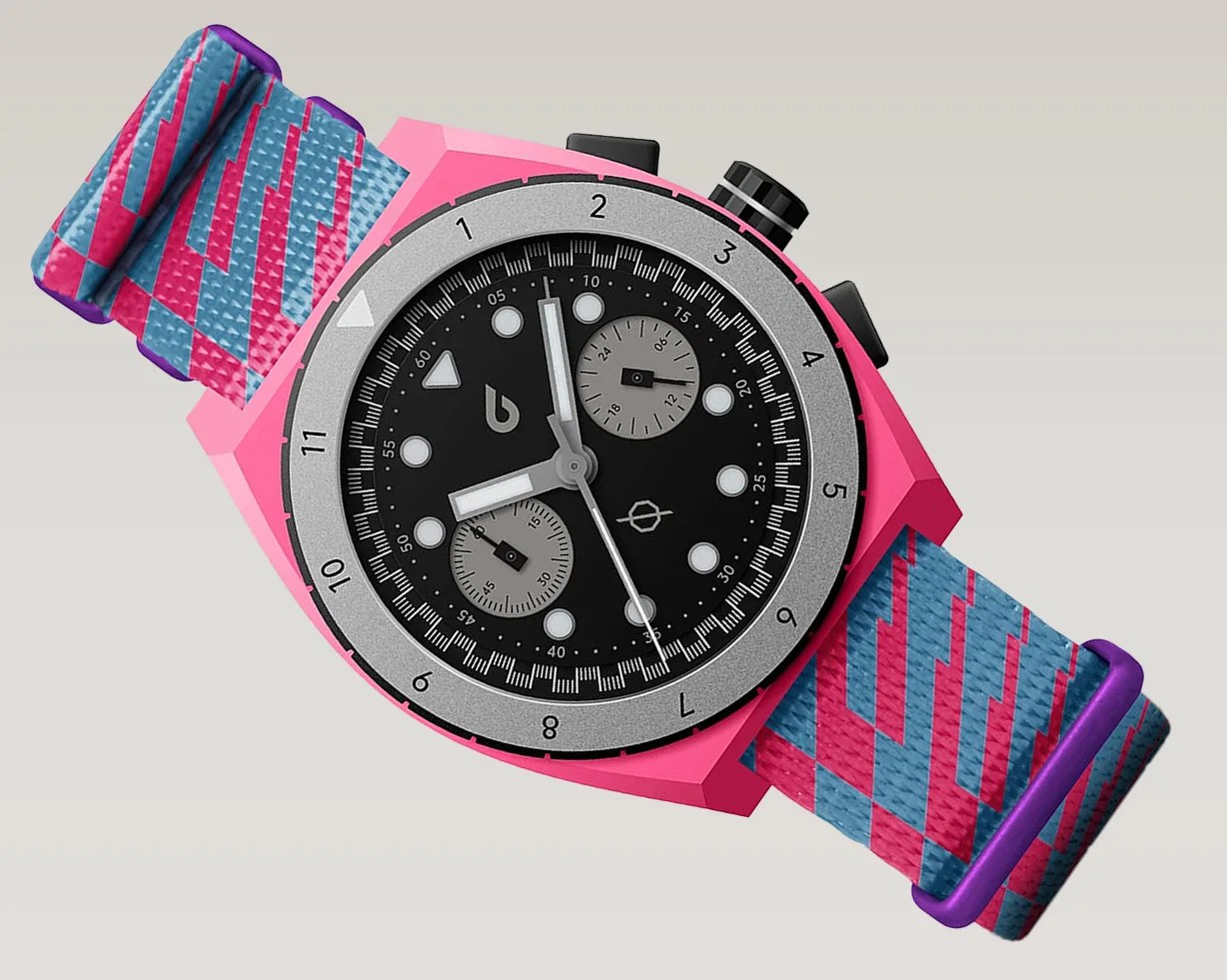 Pink watch with black dial, silver bezel, and blue and pink patterned fabric strap with purple loops.