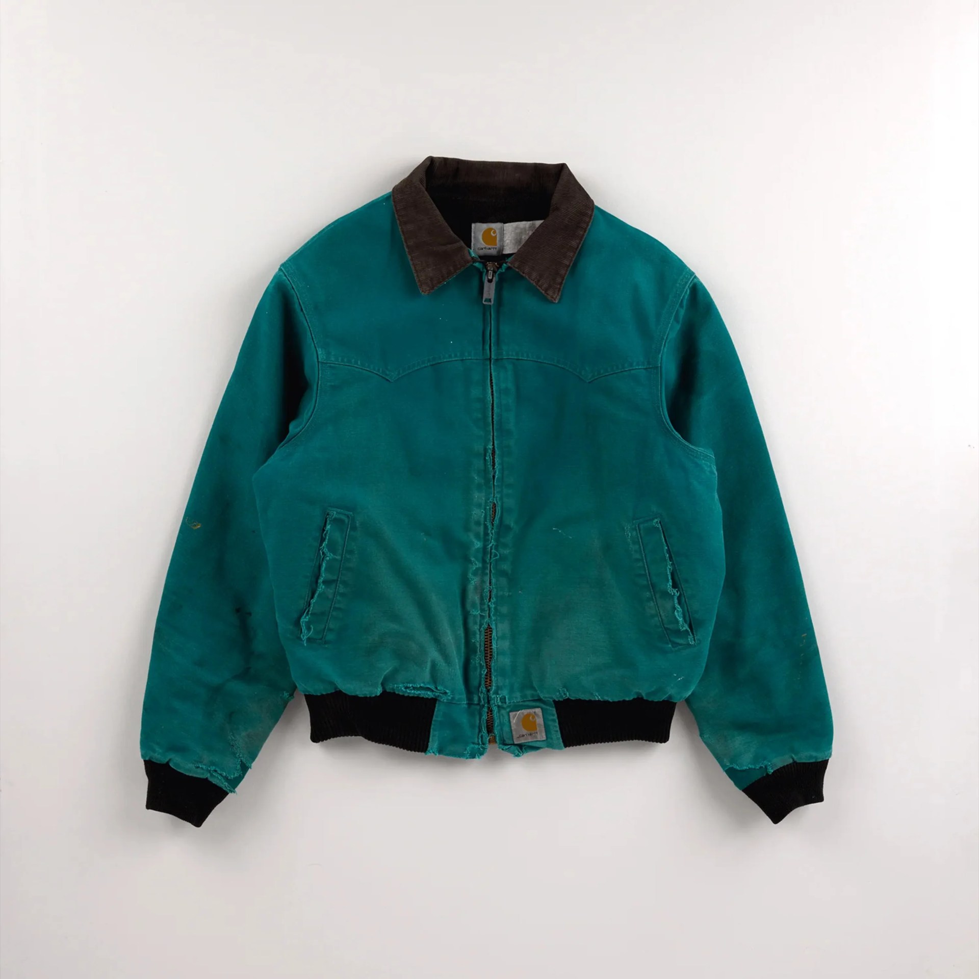 Teal Carhartt jacket with black corduroy collar and cuffs, front zipper, and side pockets.