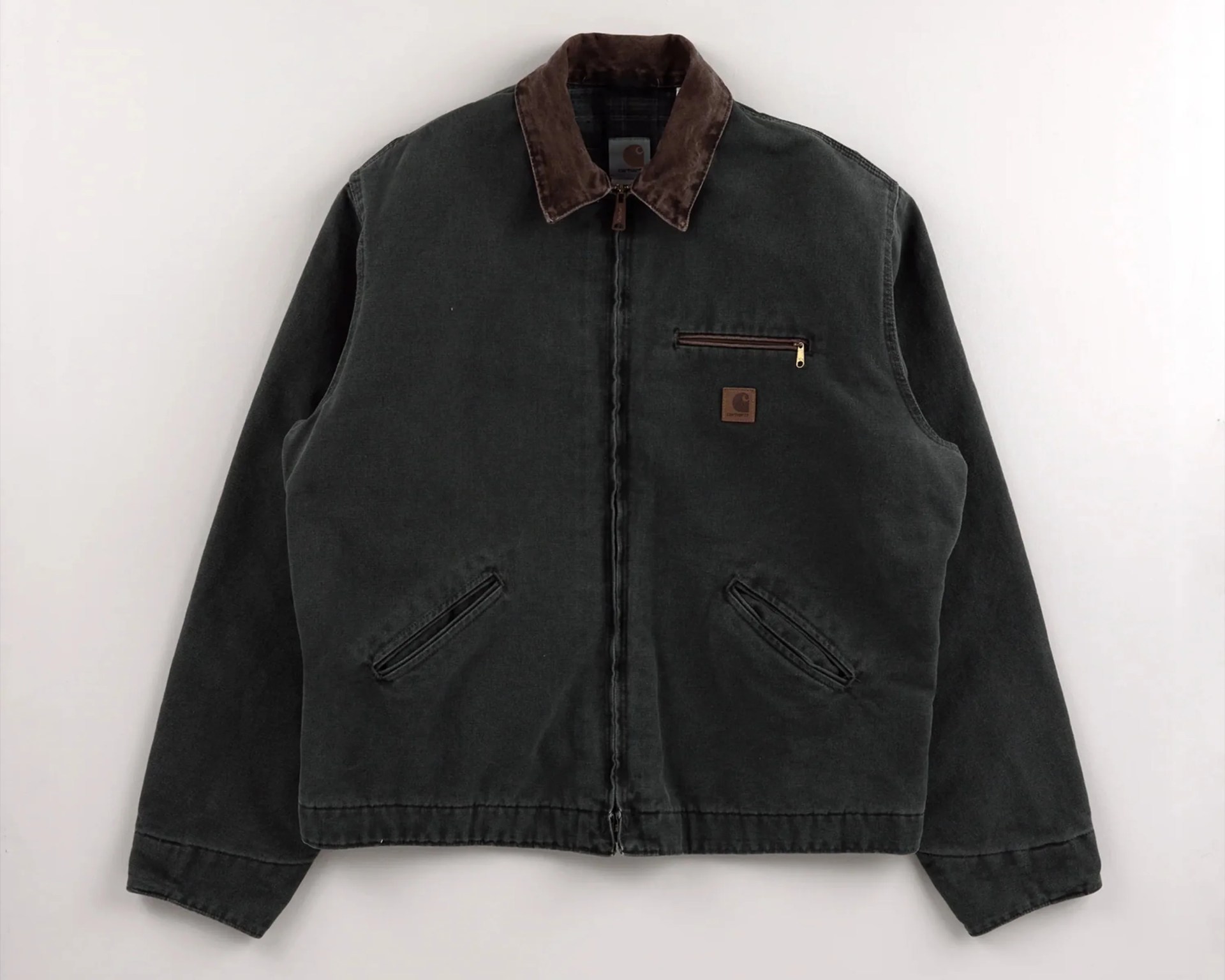 Dark green Carhartt jacket with brown corduroy collar and zippered chest pocket.