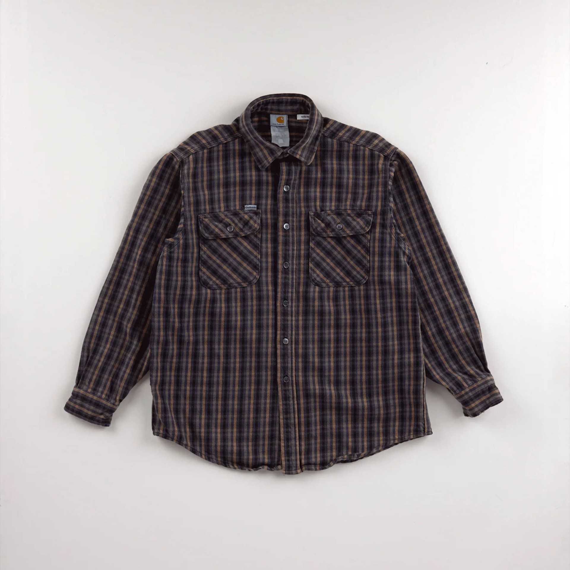 Brown and black plaid button-up shirt with two front chest pockets laid flat on a white surface.