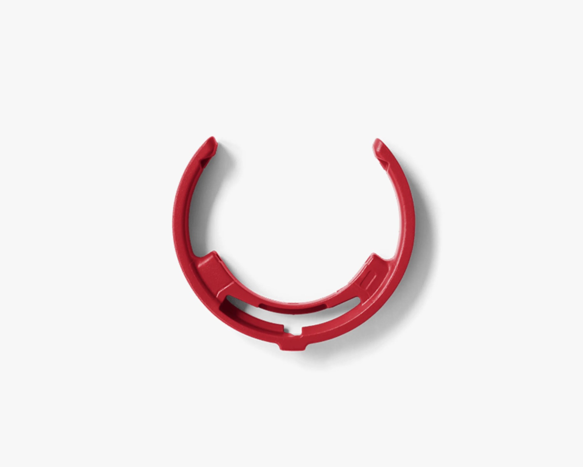 Red plastic circular clip with open ends and internal ridges on a white background.