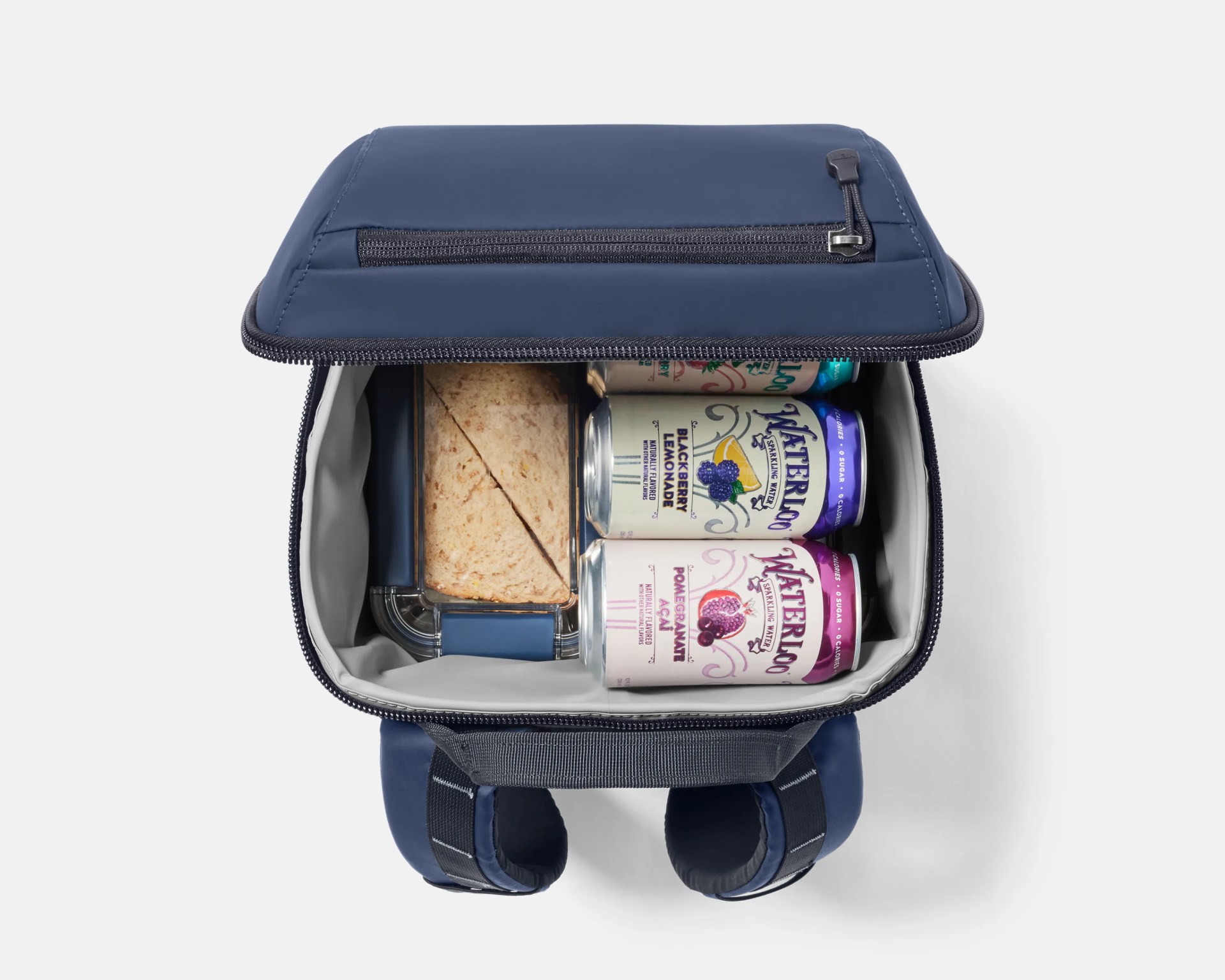 Open navy blue insulated lunch bag with a sandwich in a plastic container and three cans of sparkling water inside.