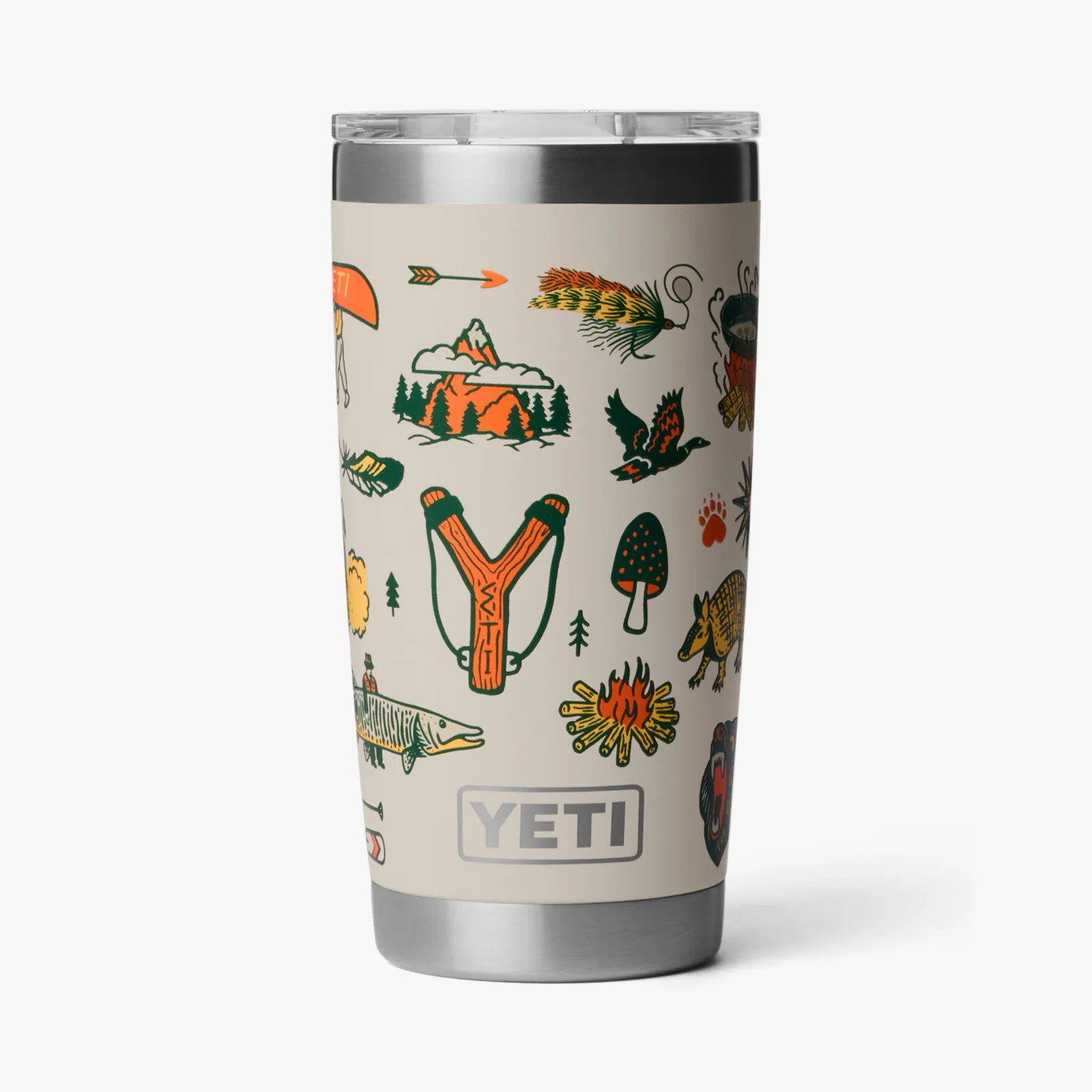 Cream-colored YETI tumbler with colorful outdoor-themed illustrations including a slingshot, campfire, fish, and mountains.