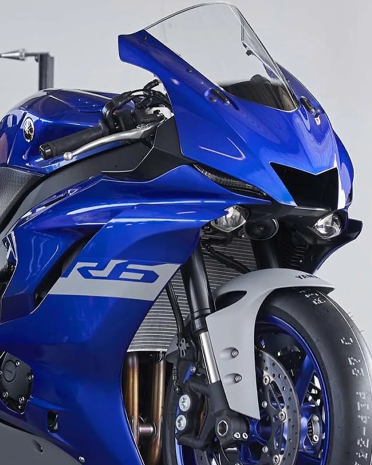 Blue Yamaha R6 sport motorcycle front with clear windshield and white front fender.