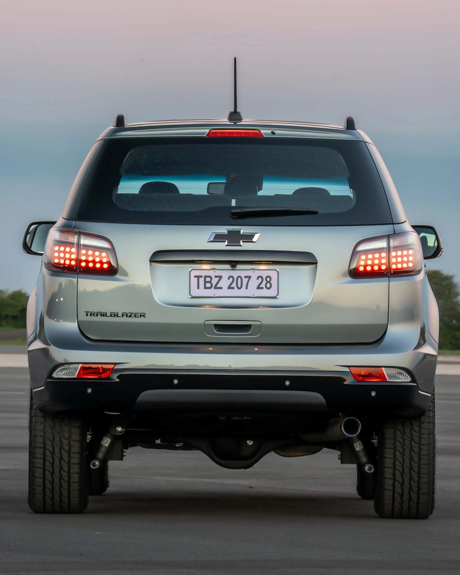 Silver Chevrolet Trailblazer SUV rear view with illuminated taillights and license plate TBZ 207 28.