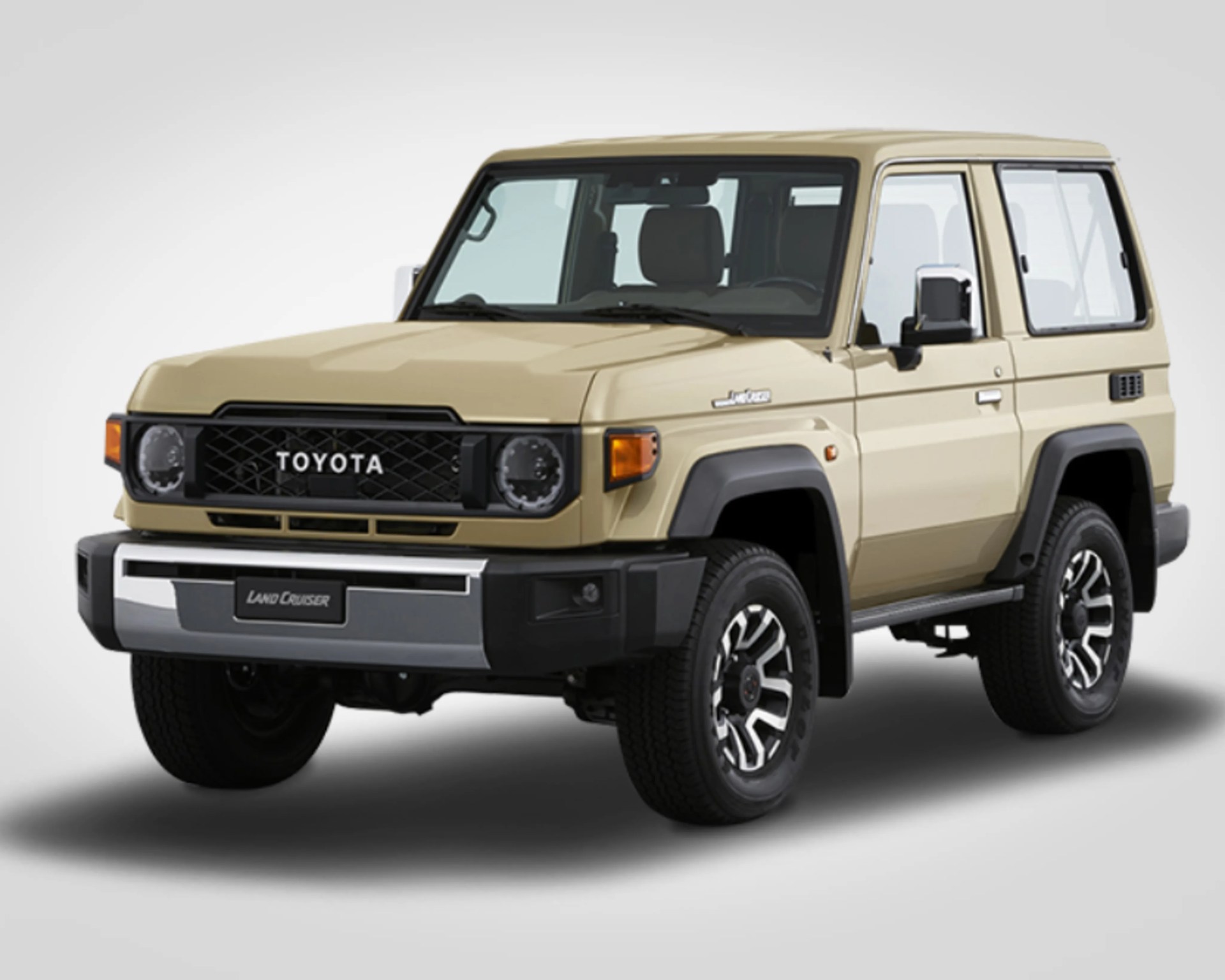 Beige Toyota Land Cruiser SUV with black grille and silver bumper on a white background.