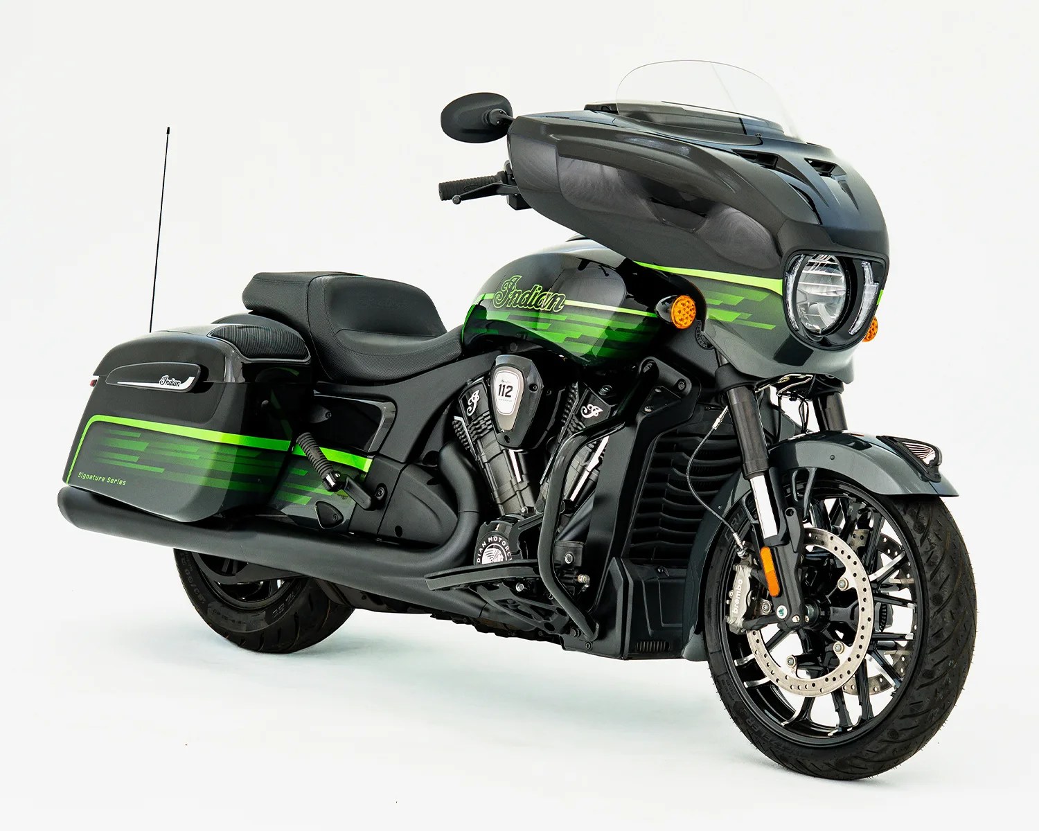 Black and green Indian motorcycle with large front fairing and saddlebags on a white background.
