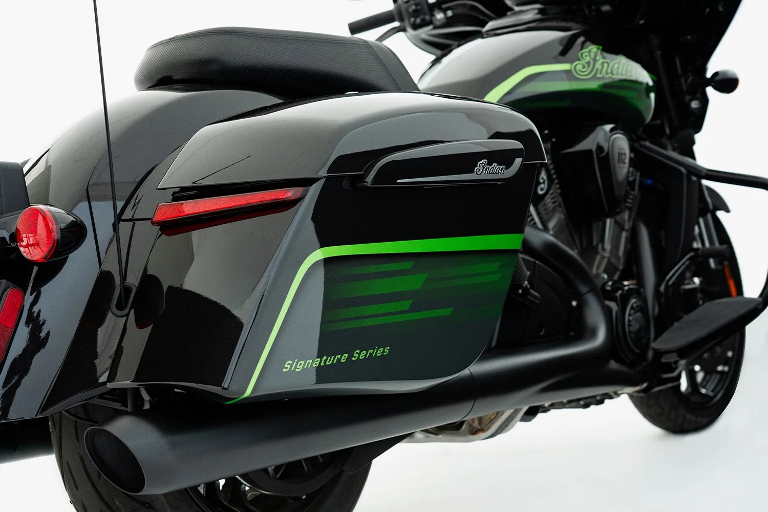 Close-up of a black Indian motorcycle saddlebag with green stripes and "Signature Series" text.