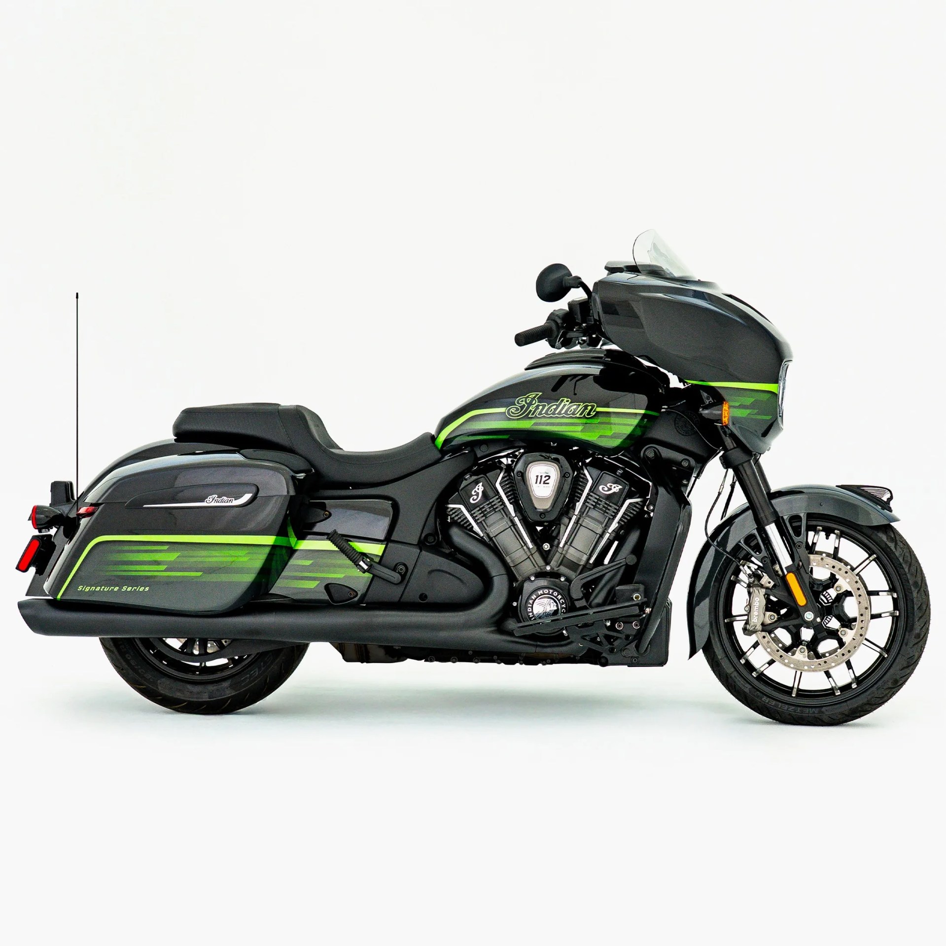Black and green Indian motorcycle with saddlebags and a windshield on a white background.
