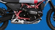 Close-up of a motorcycle engine with red frame, black casing labeled "R12," and silver exhaust pipe against a blue background.