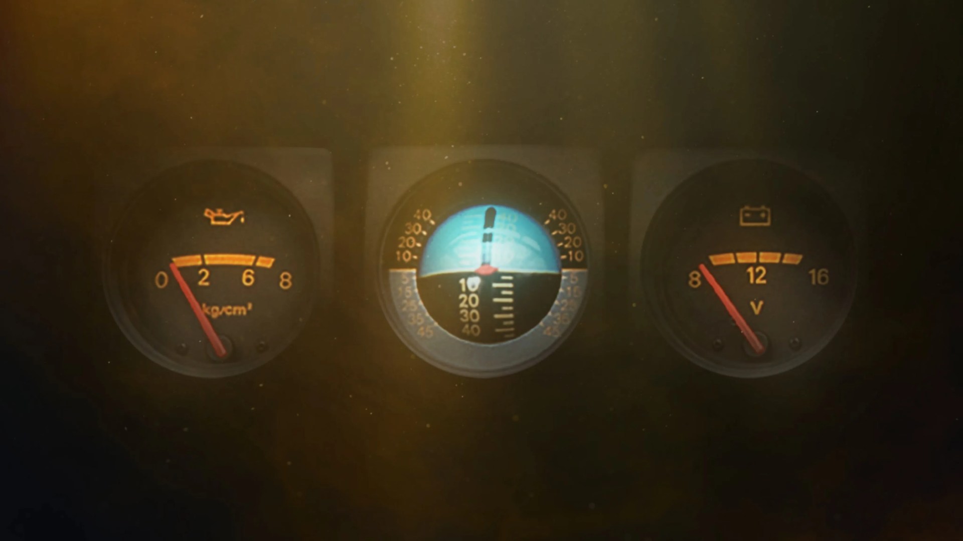 Three round vehicle dashboard gauges with oil pressure, artificial horizon, and battery voltage indicators lit in dim light.