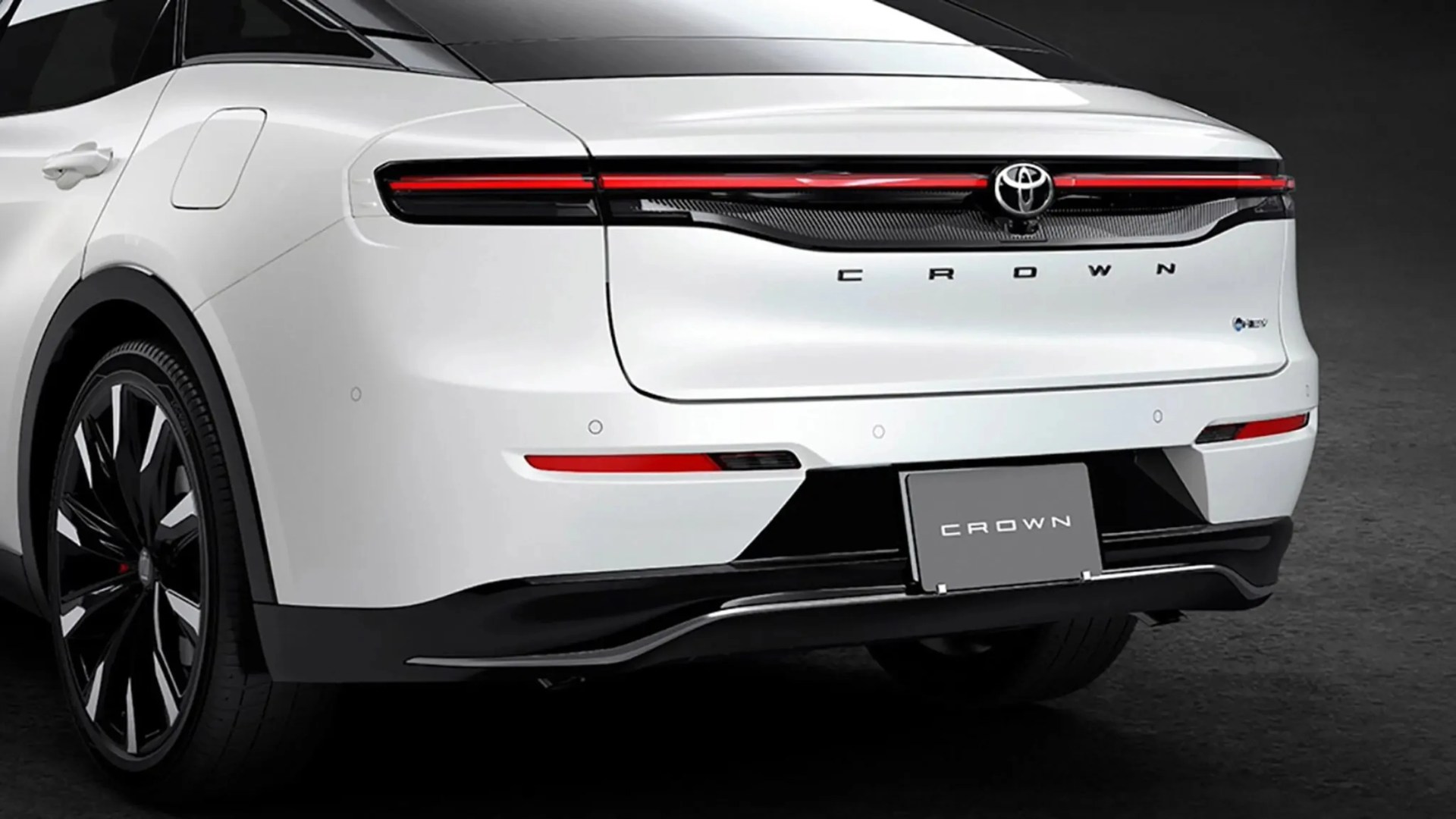 Rear view of a white Toyota Crown with sleek black and red taillights and black alloy wheels.
