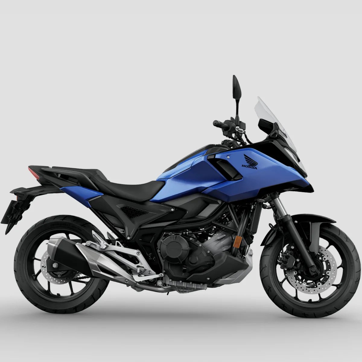 Blue and black Honda motorcycle with windshield and disc brakes on gray background.