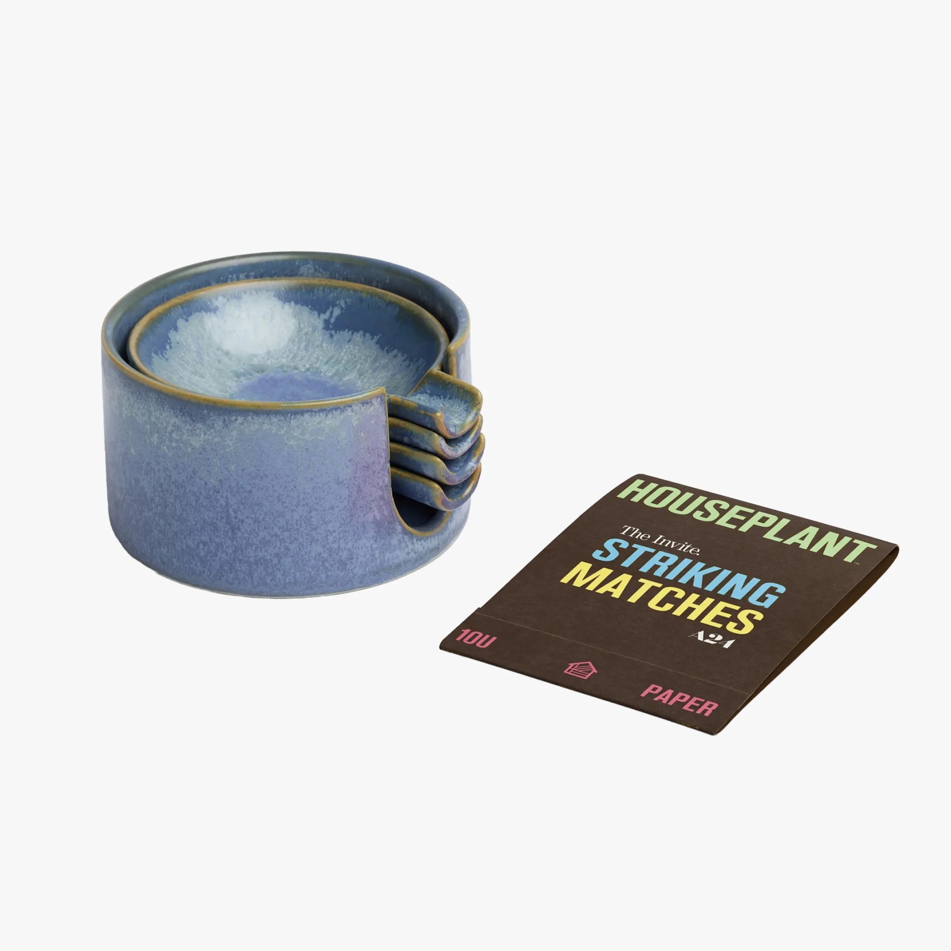 Set of five blue ceramic coasters with a matching holder next to a brown box of Houseplant striking matches.