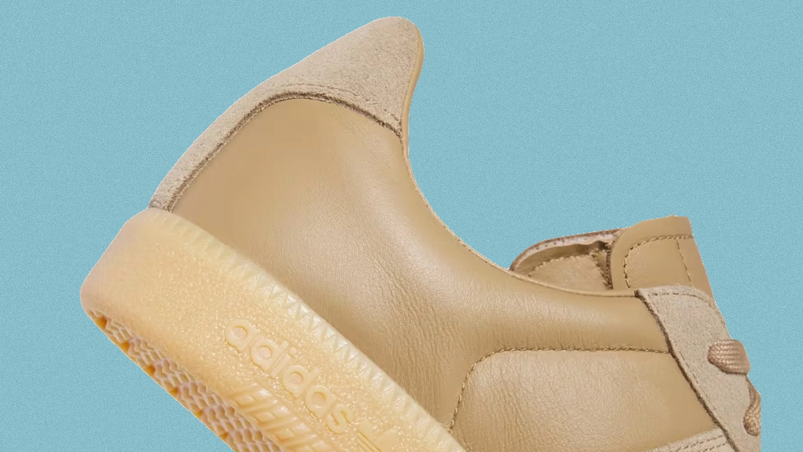 Close-up of a tan Adidas sneaker with leather and suede upper and a translucent gum sole.
