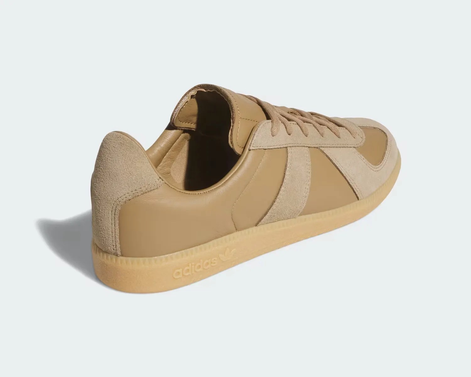 Tan leather and suede Adidas sneaker with gum sole viewed from the back side.