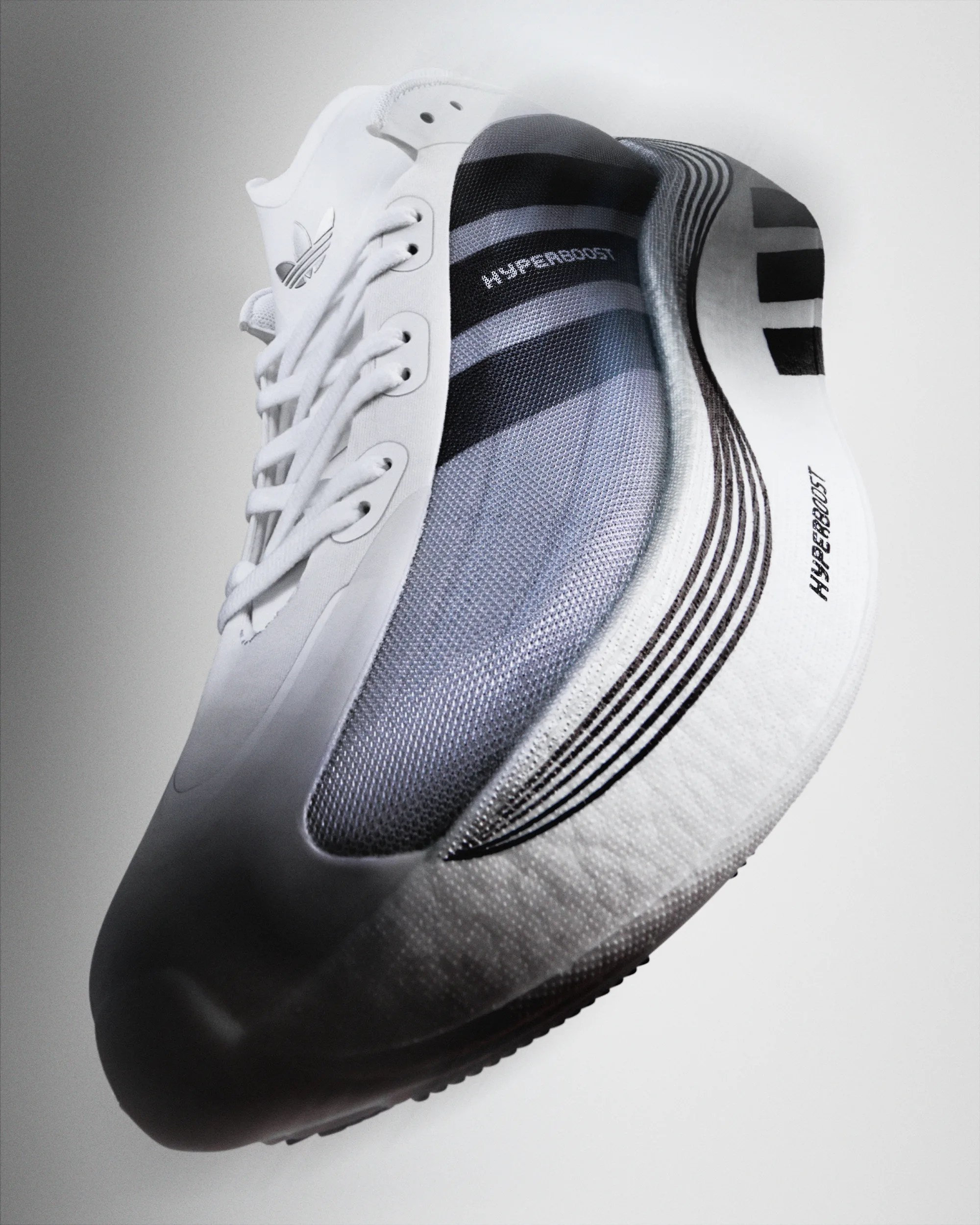 White and gray Adidas Hyperboost sneaker with mesh upper and black stripes on white sole.