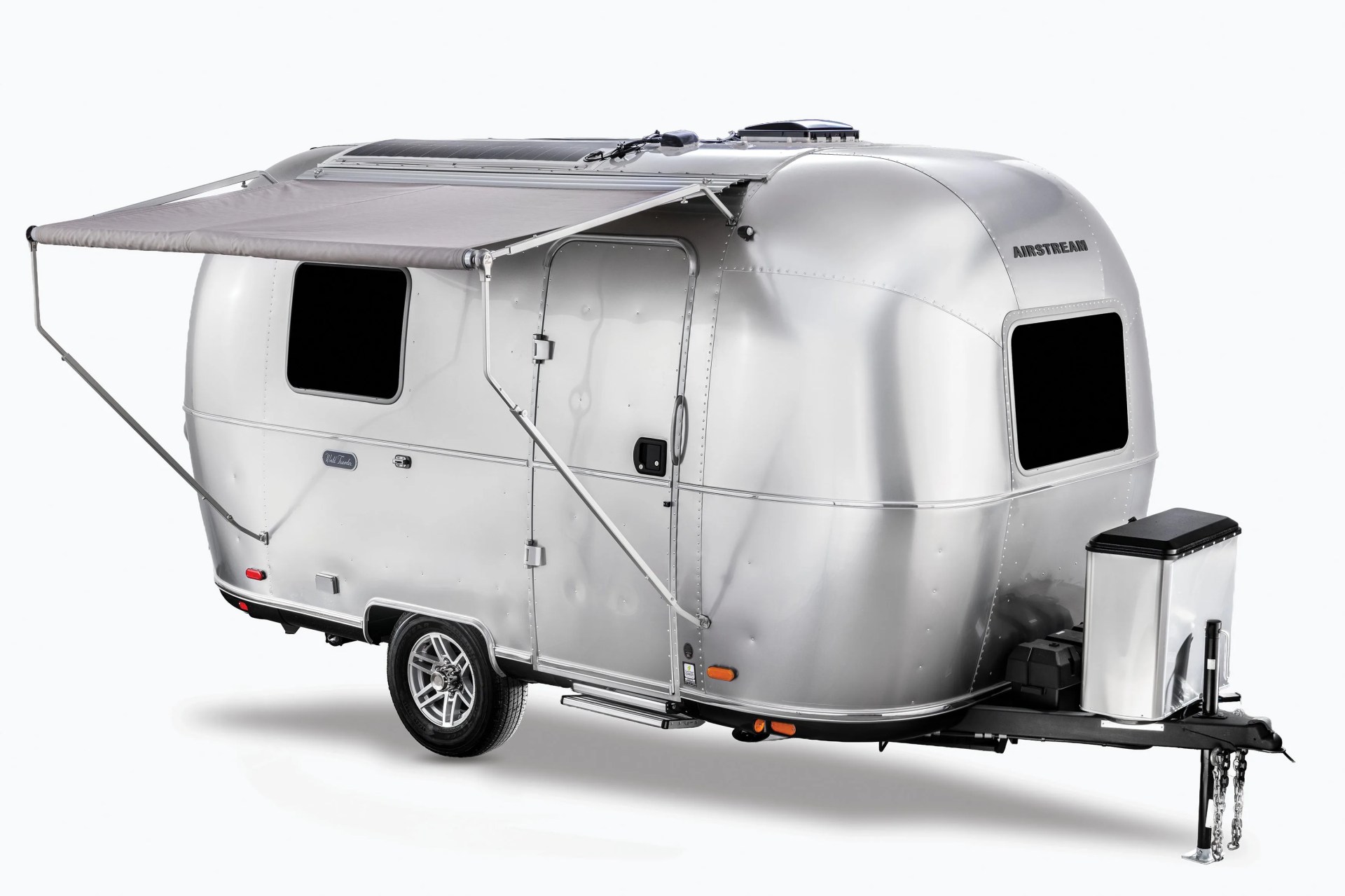 Silver Airstream travel trailer with extended gray awning and solar panels on the roof.