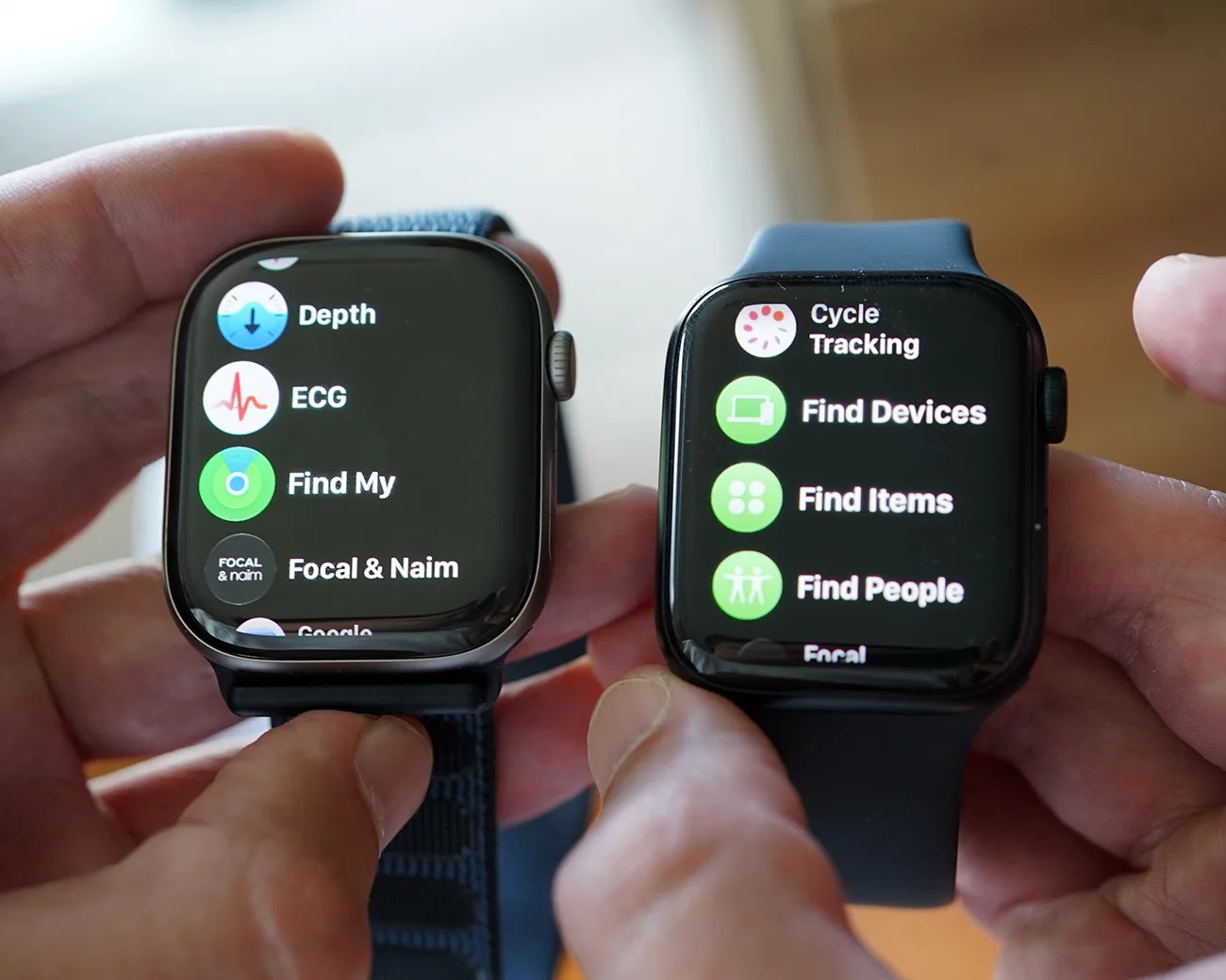 Two smartwatches with black straps held in hands, displaying health and tracking app menus on their screens.
