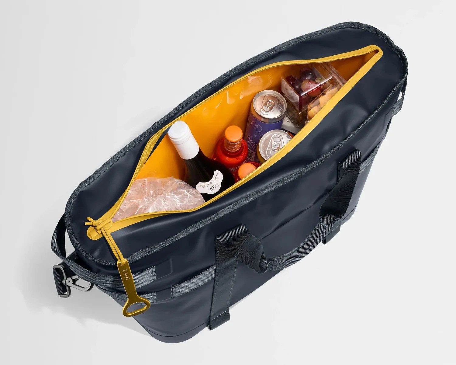 Navy insulated cooler bag with yellow zipper, containing bottles, cans, and packaged snacks.