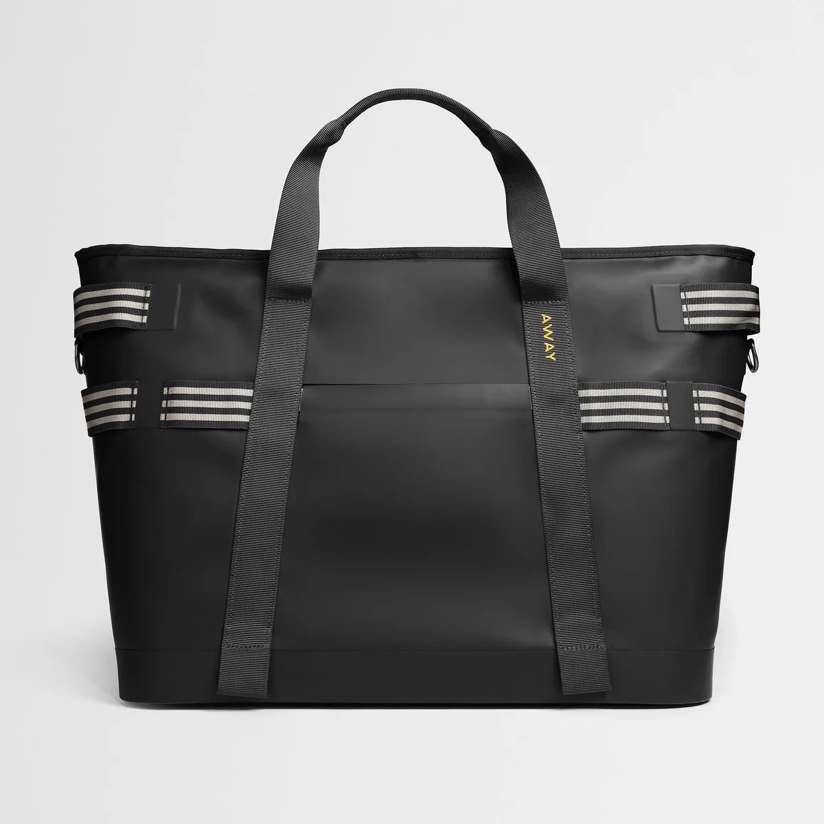 Black rectangular tote bag with dual handles and striped side straps, featuring the brand name "AWAY" on one handle.