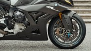 Close-up of a BMW motorcycle front wheel and carbon fiber bodywork with Brembo brake caliper.