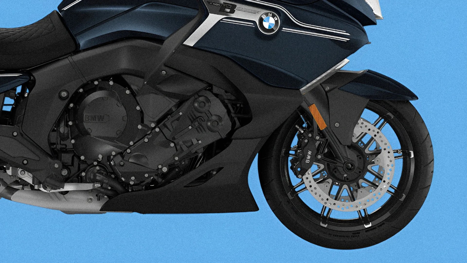 Close-up of the black BMW motorcycle engine and front wheel with disc brake against a blue background.