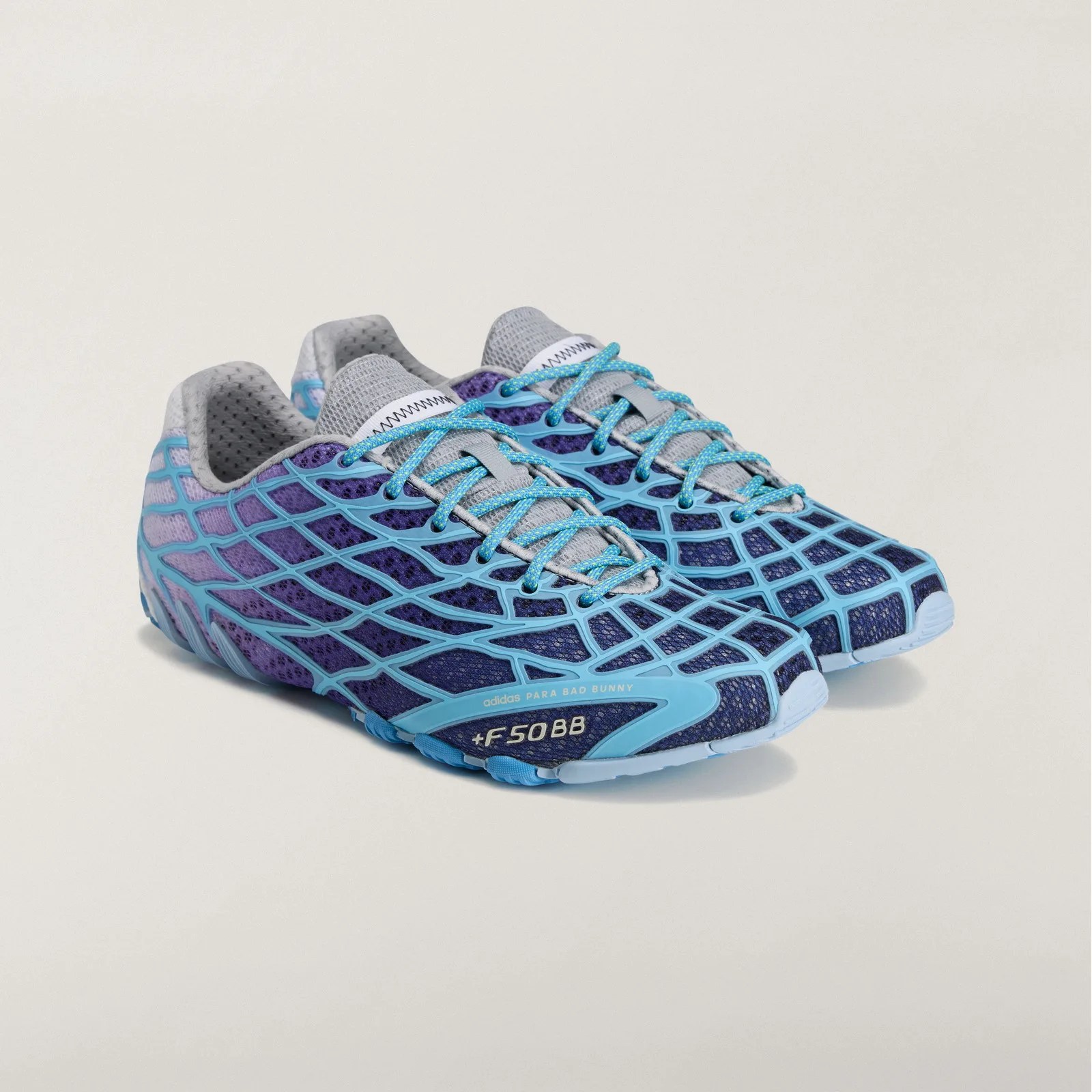 Pair of purple and blue Adidas F50 BB sneakers with light blue web-like overlay and blue laces on a white background.