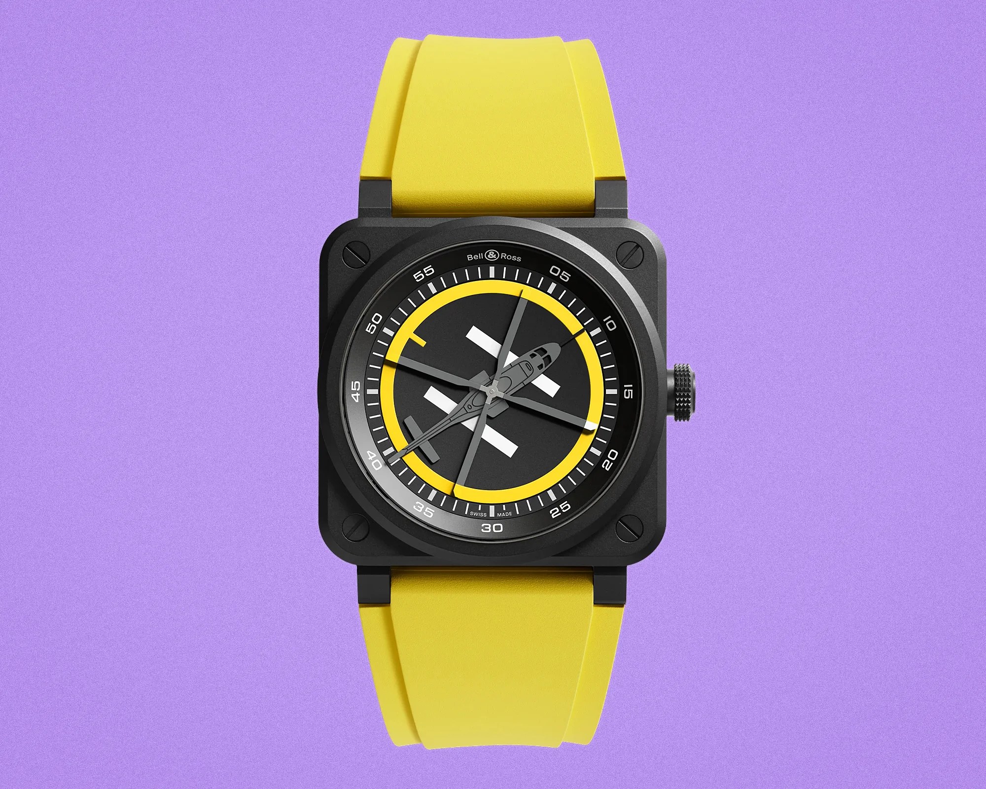 Square black Bell & Ross wristwatch with yellow rubber strap and helicopter-shaped hands on a purple background.