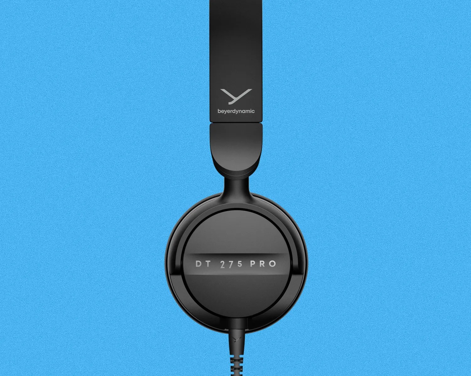 Black Beyerdynamic DT 275 Pro over-ear headphone ear cup and headband section on a blue background.