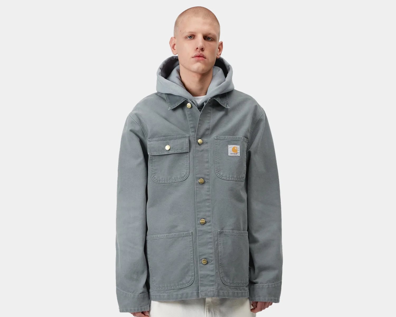 Gray Carhartt jacket with button front and four pockets worn over a light gray hoodie.